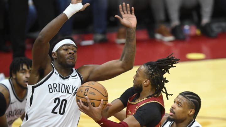 Mar 10, 2024; Cleveland, Ohio, USA; Cleveland Cavaliers guard Darius Garland (10) drives to the basket between Brooklyn Nets center Day'Ron Sharpe (20) and guard Dennis Smith Jr. (4) in the third quarter at Rocket Mortgage FieldHouse. Mandatory Credit: David Richard-USA TODAY Sports