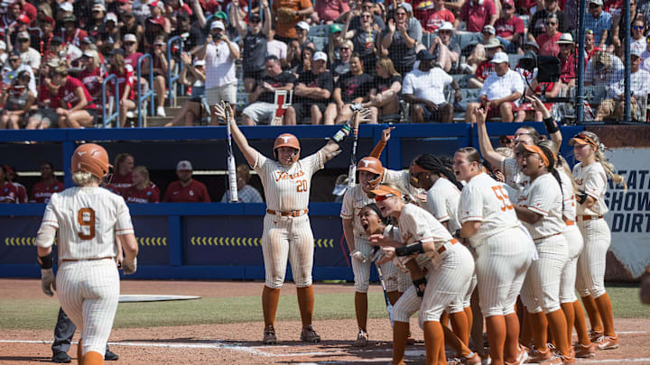 May 31, 2025; Oklahoma City, OK, USA;  Texas Longhorns players wait at home plate for infielder Joley Mitchell (9) after she hit a home run in the sixth inning during the NCAA Softball Women's College World Series at Devon Park. Mandatory Credit: Brett Rojo-Imagn Images