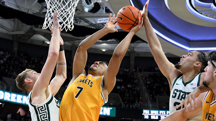Dec 16, 2025; East Lansing, Michigan, USA;  Toledo Rockets forward Sean Craig (7) gets blocked by Michigan State Spartans forward Jesse McCulloch (35) during the first half at Jack Breslin Student Events Center. Mandatory Credit: Dale Young-Imagn Images