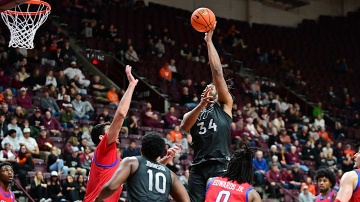 Feb 5, 2025; Blacksburg, Virginia, USA; Virginia Tech Hokies forward Mylyjael Poteat (34) shoots a shot as Southern Methodist Mustangs center Samet Yigitoglu (24) defends during the second half at Cassell Coliseum. Mandatory Credit: Brian Bishop-Imagn Images