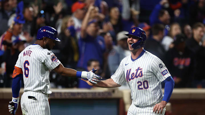 Oct 18, 2024; New York City, New York, USA; New York Mets first baseman Pete Alonso (20) high-fives right fielder Starling Marte (6) after scoring during the fourth inning against the Los Angeles Dodgers during game five of the NLCS for the 2024 MLB playoffs at Citi Field. Mandatory Credit: Vincent Carchietta-Imagn Images