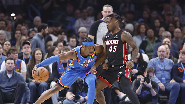 Feb 12, 2025; Oklahoma City, Oklahoma, USA; Miami Heat guard Davion Mitchell (45) defends a drive by Oklahoma City Thunder guard Shai Gilgeous-Alexander (2) during the first quarter at Paycom Center. Mandatory Credit: Alonzo Adams-Imagn Images