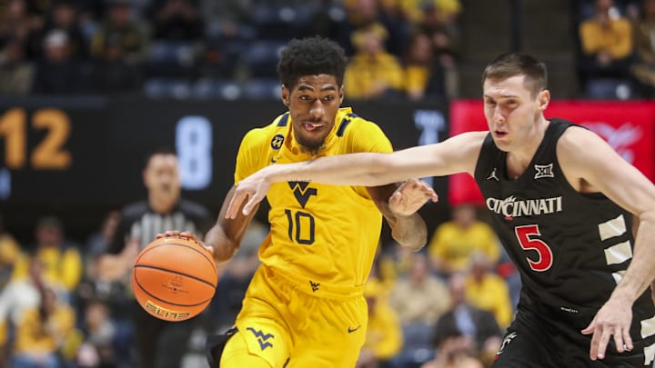 Feb 19, 2025; Morgantown, West Virginia, USA; West Virginia Mountaineers guard Sencire Harris (10) drives against Cincinnati Bearcats guard CJ Fredrick Jr. (5) during the first half at WVU Coliseum. Mandatory Credit: Ben Queen-Imagn Images
