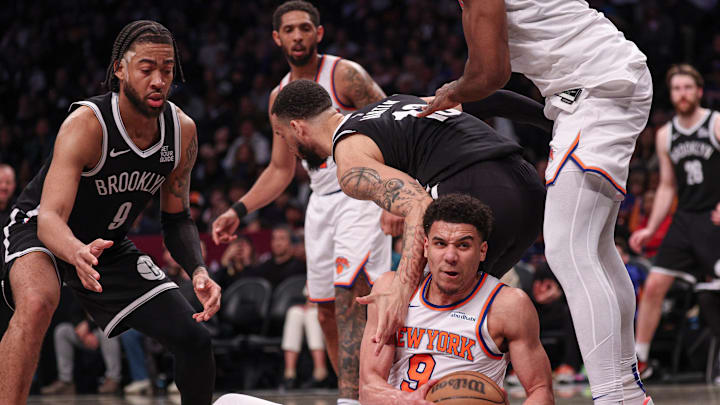Apr 13, 2025; Brooklyn, New York, USA; New York Knicks forward Kevin McCullar Jr. (9) secures a loose ball in front of Brooklyn Nets forward Trendon Watford (9) during the second half at Barclays Center. Mandatory Credit: Vincent Carchietta-Imagn Images