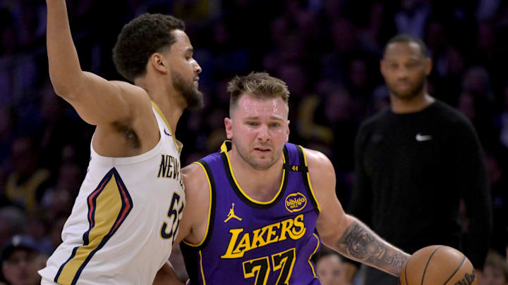 Apr 4, 2025; Los Angeles, California, USA;  Los Angeles Lakers guard Luka Doncic (77) is defended by New Orleans Pelicans forward Jeremiah Robinson-Earl (50) in the first half at Crypto.com Arena. Mandatory Credit: Jayne Kamin-Oncea-Imagn Images