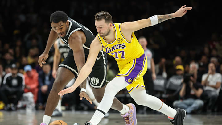 Feb 3, 2026; Brooklyn, New York, USA;  Brooklyn Nets center Day'ron Sharpe (20) and Los Angeles Lakers guard Luka Doncic (77) fight for a loose ball in the first quarter at Barclays Center. Mandatory Credit: Wendell Cruz-Imagn Images