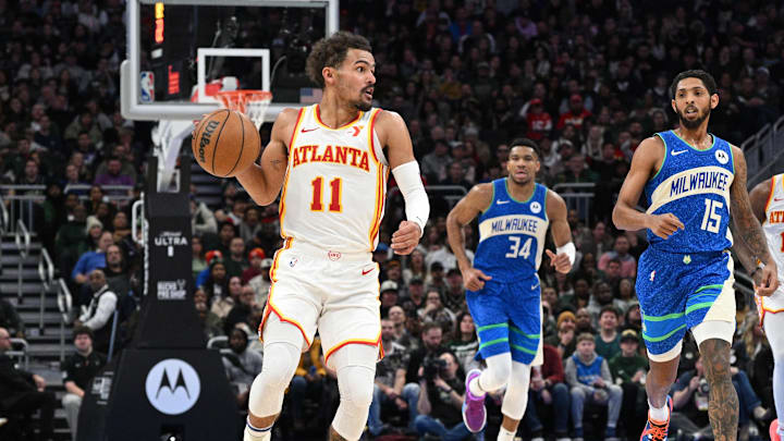 Dec 2, 2023; Milwaukee, Wisconsin, USA; Atlanta Hawks guard Trae Young (11) pushes the ball up the court against Milwaukee Bucks center Brook Lopez (11) at Fiserv Forum. Mandatory Credit: Michael McLoone-Imagn Images