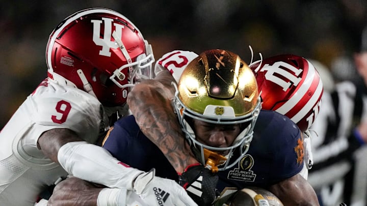 Indiana Hoosiers defensive back Jamier Johnson (9) and defensive back Terry Jones Jr. (12) tackle Notre Dame Fighting Irish running back Jadarian Price (24) during the first half of a game between the Indiana Hoosiers and the Notre Dame Fighting Irish in first round of the College Football Playoff on Friday, Dec. 20, 2024, in South Bend. Indiana Hoosiers defensive back Jamier Johnson (9) and defensive back Terry Jones Jr. (12) tackle Notre Dame Fighting Irish running back Jadarian Price (24) during the first half of a game between the Indiana Hoosiers and the Notre Dame Fighting Irish in first round of the College Football Playoff on Friday, Dec. 20, 2024, in South Bend.