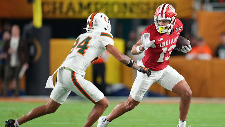 Jan 19, 2026; Miami Gardens, FL, USA; Indiana Hoosiers wide receiver Elijah Sarratt (13) runs with the ball against Miami Hurricanes defensive back Ethan O'Connor (24) during the first half of the College Football Playoff National Championship game at Hard Rock Stadium. Mandatory Credit: Kirby Lee-Imagn Images
