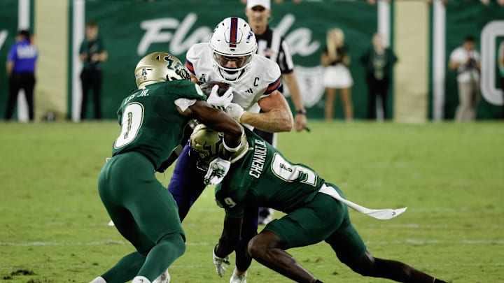 Oct 18, 2025; Tampa, Florida, USA;  South Florida Bulls cornerback Jarvis Lee (0) and  defensive back James Chenault (9) combine to tackle Florida Atlantic Owls wide receiver Easton Messer (8) during the first quarter at Raymond James Stadium. Mandatory Credit: Reinhold Matay-Imagn Images
