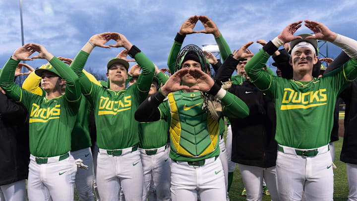 Oregon baseball players flash the “O” to fans after the Ducks beat the Toledo Rockets in their home opener at PK Park in Eugene Friday, Feb. 14, 2025.