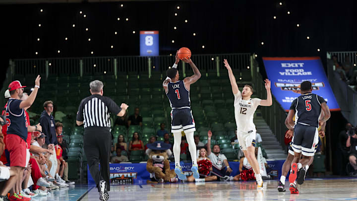 Nov 29, 2024; Paradise Island, Bahamas, BHS;  Arizona Wildcats guard Caleb Love (1) scores over West Virginia Mountaineers guard Tucker DeVries (12) during the second half at Imperial Arena at the Atlantis resort.  Mandatory Credit: Kevin Jairaj-Imagn Images
