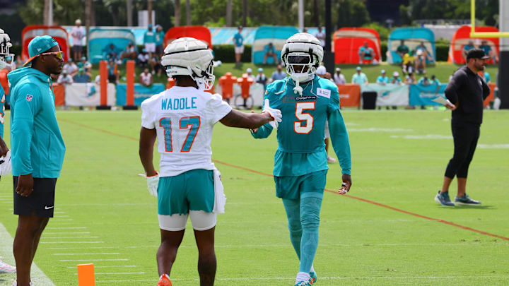 Jul 28, 2024; Miami Gardens, FL, USA; Miami Dolphins cornerback Jalen Ramsey (5) and wide receiver Jaylen Waddle (17) shake hands during training camp at Baptist Health Training Complex. Mandatory Credit: Sam Navarro-USA TODAY Sports
