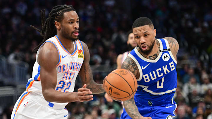 Mar 16, 2025; Milwaukee, Wisconsin, USA;  Oklahoma City Thunder guard Cason Wallace (22) drives for the basket against Milwaukee Bucks guard Damian Lillard (0) in the second quarter at Fiserv Forum. Mandatory Credit: Benny Sieu-Imagn Images