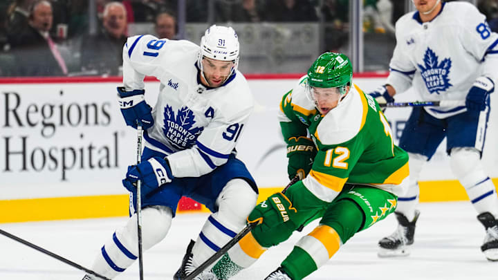 Nov 3, 2024; Saint Paul, Minnesota, USA; Toronto Maple Leafs center John Tavares (91) protects the puck from Minnesota Wild left wing Matt Boldy (12) during the first period at Xcel Energy Center. Mandatory Credit: Brace Hemmelgarn-Imagn Images