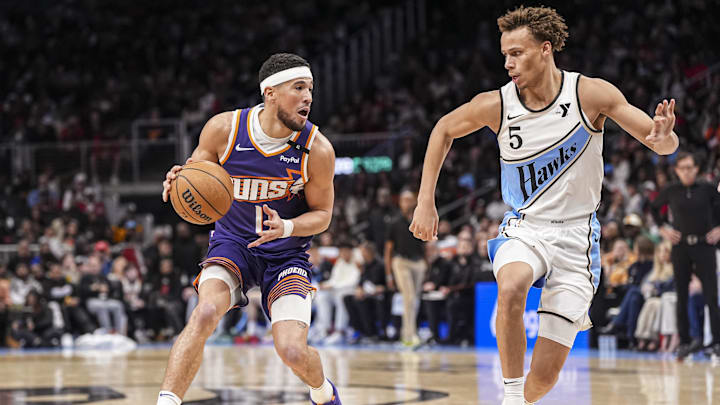 Jan 14, 2025; Atlanta, Georgia, USA; Phoenix Suns guard Devin Booker (1) is defended by Atlanta Hawks guard Dyson Daniels (5) during the second half at State Farm Arena. Mandatory Credit: Dale Zanine-Imagn Images