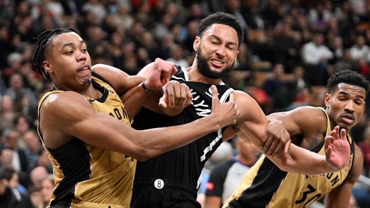 Feb 22, 2024; Toronto, Ontario, CAN;  Brooklyn Nets guard Ben Simmons (10) battles to reach a rebound against Toronto Raptors forward Scottie Barnes (4) and guard Ochai Agbaji (30) in the second half at Scotiabank Arena. Mandatory Credit: Dan Hamilton-USA TODAY Sports
