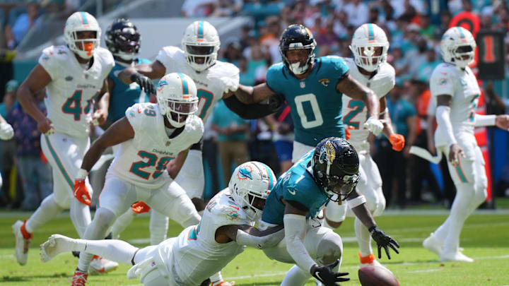 Miami Dolphins safety Jevon Holland (8) punches the ball away from Jacksonville Jaguars running back Travis Etienne Jr. (1) causing a fumble that was recovered by the Dolphins in the end zone during the third quarter at Hard Rock Stadium.