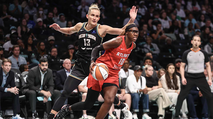 Sep 22, 2024; Brooklyn, New York, USA; Atlanta Dream guard Rhyne Howard (10) drives past  New York Liberty forward Leonie Fiebich (13) during game one of the first round of the 2024 WNBA Playoffs at Barclays Center. Mandatory Credit: Wendell Cruz-Imagn Images