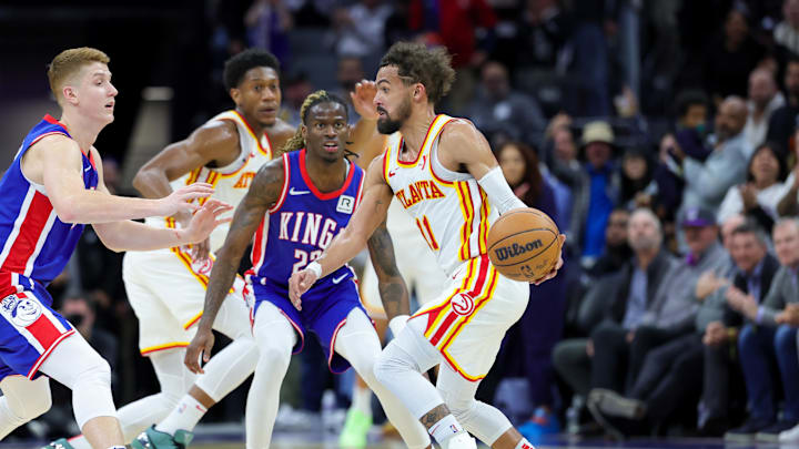 Nov 18, 2024; Sacramento, California, USA; Atlanta Hawks guard Trae Young (11) is defended by Sacramento Kings guard Keon Ellis (23) and guard Kevin Huerter (9) during the fourth quarter at Golden 1 Center. Mandatory Credit: Sergio Estrada-Imagn Images