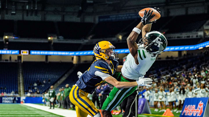Detroit Cass Tech WR Corey Sadler Jr. catches a touchdown pass, while being covered by Hudsonville Ty Ykema in the second quarter, during the MHSAA Division 1 football finals at Ford Field in Detroit on Saturday, Nov. 30, 2024.