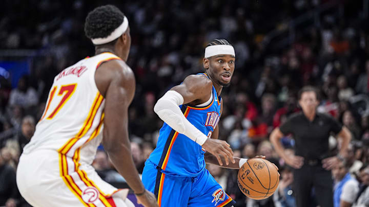 Oct 25, 2025; Atlanta, Georgia, USA; Oklahoma City Thunder guard Shai Gilgeous-Alexander (2) dribbles against Atlanta Hawks forward Onyeka Okongwu (17) during the second half at State Farm Arena. Mandatory Credit: Dale Zanine-Imagn Images