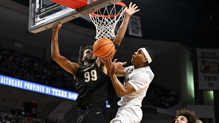 Vanderbilt Commodores forward Devin McGlockton (99) fouls Texas A&M Aggies guard Zhuric Phelps (1) during the first half at Reed Arena. Vanderbilt Commodores forward Devin McGlockton (99) fouls Texas A&M Aggies guard Zhuric Phelps (1) during the first half at Reed Arena.