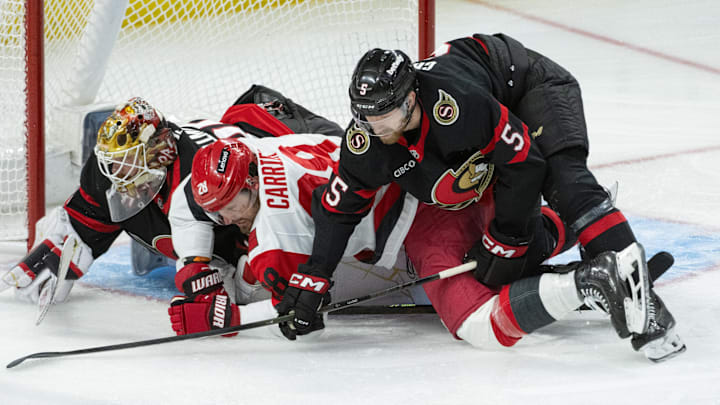 Apr 23, 2026; Ottawa, Ontario, CAN; Carolina Hurricanes left wing William Carrier (28) is taken down as he battles with Ottawa Senators defenseman Cameron Crotty (5) in the third period of game three of the first round of the 2026 Stanley Cup Playoffs at the Canadian Tire Centre. Mandatory Credit: Marc DesRosiers-Imagn