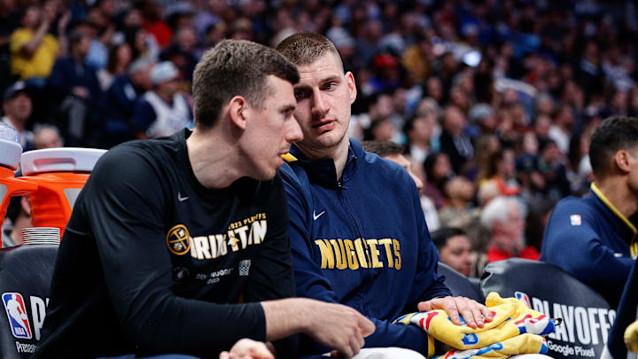 Denver Nuggets center Nikola Jokic (15) talks with forward Vlatko Cancar (31) on the bench while keeping a heating pad on his wrist in the fourth quarter against the Minnesota Timberwolves during game two of the 2023 NBA Playoffs at Ball Arena. Mandatory Credit: Isaiah J. Downing-Imagn Images