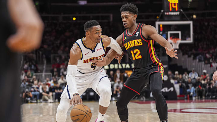 Dec 8, 2024; Atlanta, Georgia, USA; Denver Nuggets guard Russell Westbrook (4) dribbles against Atlanta Hawks forward De'Andre Hunter (12) during the first half at State Farm Arena. Mandatory Credit: Dale Zanine-Imagn Images