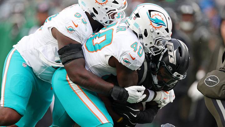 Miami Dolphins defensive tackle Zeek Biggers (93) and linebacker Willie Gay Jr. (40) tackle New York Jets wide receiver John Metchie III (3) during the second half at MetLife Stadium in December 2025. Miami Dolphins defensive tackle Zeek Biggers (93) and linebacker Willie Gay Jr. (40) tackle New York Jets wide receiver John Metchie III (3) during the second half at MetLife Stadium in December 2025.