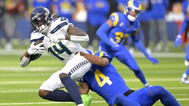 Jan 5, 2025; Inglewood, California, USA; Seattle Seahawks wide receiver DK Metcalf (14) is stopped by Los Angeles Rams cornerback Ahkello Witherspoon (4) after a complete pass in the first half at SoFi Stadium. Mandatory Credit: Jayne Kamin-Oncea-Imagn Images