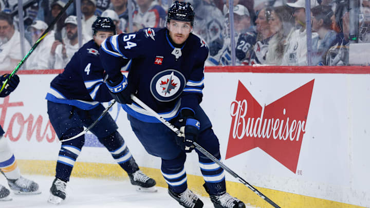 Apr 19, 2025; Winnipeg, Manitoba, CAN; Winnipeg Jets defenseman Dylan Samberg (54) looks to make a pass against St. Louis Blues during the first period in game one of the first round of the 2025 Stanley Cup Playoffs at Canada Life Centre. Mandatory Credit: Terrence Lee-Imagn Images