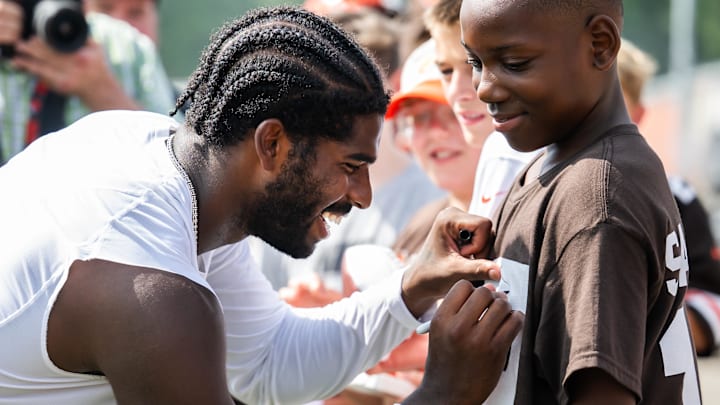 Jul 26, 2025; Berea, OH, USA; Cleveland Browns quarterback Shedeur Sanders (12) signs an autograph for a fan during training camp at CrossCountry Mortgage Campus. Mandatory Credit: Ken Blaze-Imagn Images