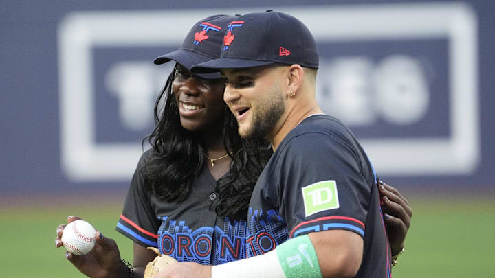 Aug 15, 2025; Toronto, Ontario, CAN; Canadian tennis player Victoria Mboko poses with Toronto Blue Jays designated hitter Bo Bichette (11) after throwing out the first pitch before a game against the Texas Rangers at Rogers Centre. Mandatory Credit: John E. Sokolowski-Imagn Images