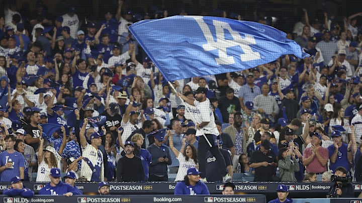 Oct 5, 2024; Los Angeles, California, USA; A Los Angeles Dodgers fans waves a flag in the eighth inning against the San Diego Padres during game one of the NLDS for the 2024 MLB Playoffs at Dodger Stadium. Mandatory Credit: Kiyoshi Mio-Imagn Images
