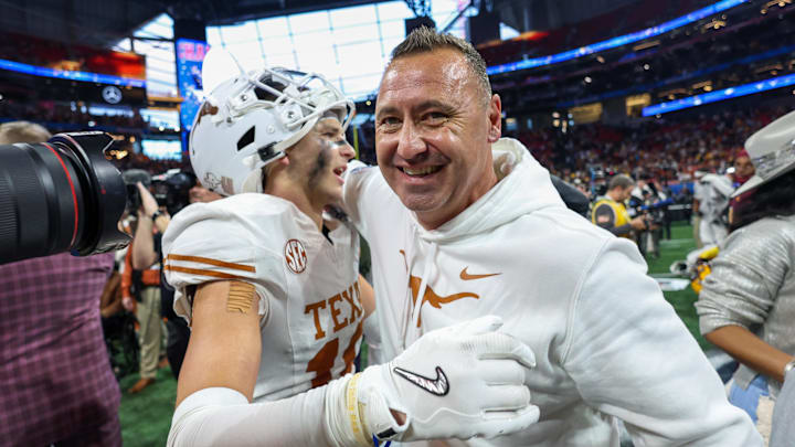 Texas Longhorns defensive back Michael Taaffe (16) and head coach Steve Sarkisian celebrate after a victory over the Arizona State Sun Devils in the Peach Bowl at Mercedes-Benz Stadium. 