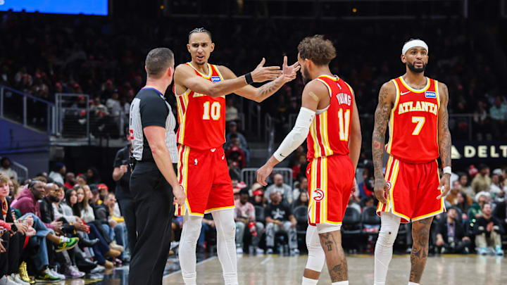 Dec 23, 2025; Atlanta, Georgia, USA; Atlanta Hawks forward Zaccharie Risacher (10), guard Trae Young (11) and guard Nickeil Alexander-Walker (7) talk to the referee after a call during the game against the Chicago Bulls during the third quarter at State Farm Arena. Mandatory Credit: Jordan Godfree-Imagn Images