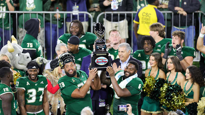 Dec 21, 2023; Boca Raton, FL, USA;  South Florida Bulls offensive lineman Donovan Jennings (73) and defensive end Immanuel Hickman (6) hold up the RoofClaim.com Boca Raton Bowl trophy after beating Syracuse Orange at FAU Stadium. Mandatory Credit: Nathan Ray Seebeck-USA TODAY Sports