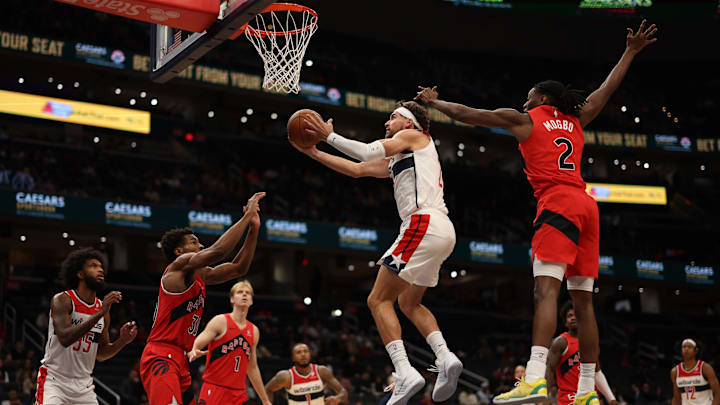 Oct 12, 2025; Washington, District of Columbia, USA; Washington Wizards forward Corey Kispert (24) shoots the ball as Toronto Raptors guard Ochai Agbaji (30) and Raptors forward Jonathan Mogbo (2) defend in the second half at Capital One Arena. Mandatory Credit: Geoff Burke-Imagn Images