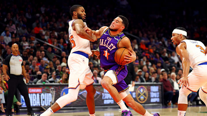 Nov 20, 2024; Phoenix, Arizona, USA; Phoenix Suns guard Devin Booker (1) drives to the basket against New York Knicks forward Mikal Bridges (25) during the second quarter at Footprint Center. Mandatory Credit: Mark J. Rebilas-Imagn Images