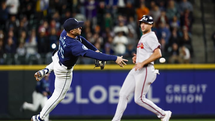Apr 30, 2024; Seattle, Washington, USA; Seattle Mariners shortstop Dylan Moore (25) throws to first base for the final out of the top of the eighth inning against the Atlanta Braves at T-Mobile Park. Mandatory Credit: Joe Nicholson-Imagn Images