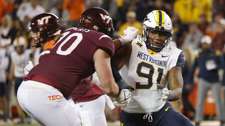 Sep 22, 2022; Blacksburg, Virginia, USA; West Virginia Mountaineers defensive lineman Sean Martin (91) tries to get past Virginia Tech Hokies offensive lineman Parker Clements (70) during the second half at Lane Stadium. Mandatory Credit: Reinhold Matay-Imagn Images Sep 22, 2022; Blacksburg, Virginia, USA; West Virginia Mountaineers defensive lineman Sean Martin (91) tries to get past Virginia Tech Hokies offensive lineman Parker Clements (70) during the second half at Lane Stadium. Mandatory Credit: Reinhold Matay-Imagn Images