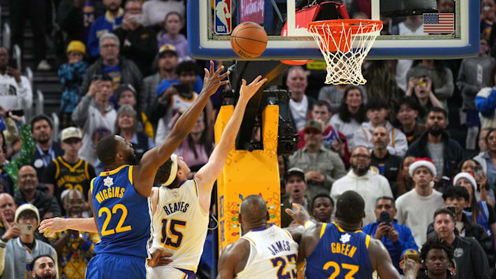 Dec 25, 2024; San Francisco, California, USA; Los Angeles Lakers guard Austin Reaves (15) scores against Golden State Warriors forward Andrew Wiggins (22) during the fourth quarter at Chase Center. Mandatory Credit: Darren Yamashita-Imagn Images