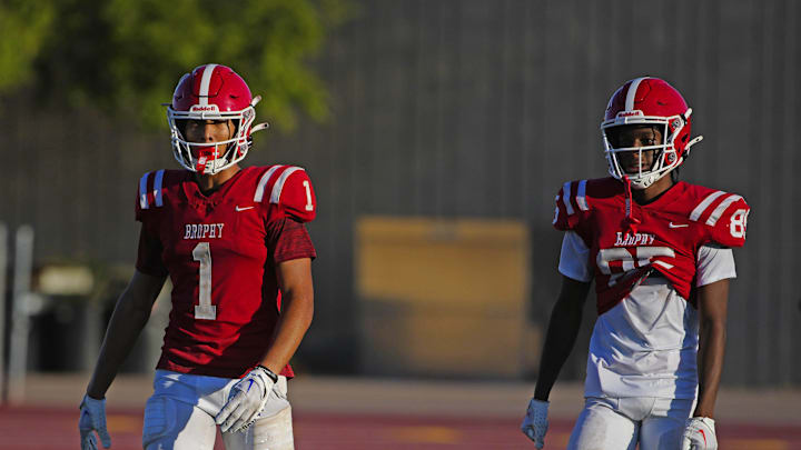 Brophy Prep wide receivers Devin Fitzgerald (1) and Donovan McNabb Jr. (85) listen to coaches during a practice at Brophy College Prepatory in Phoenix on Sept. 4, 2024.