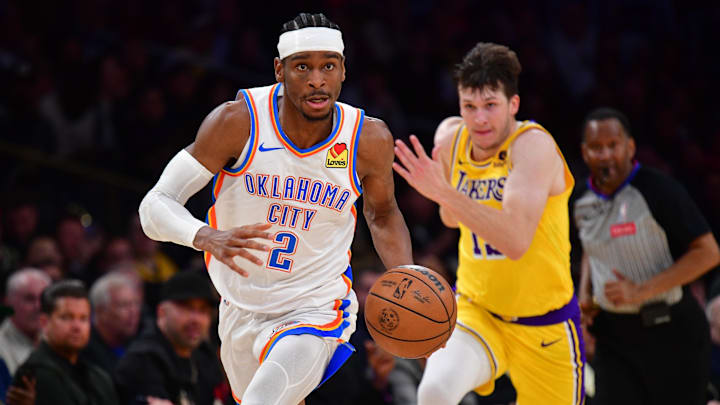 Mar 4, 2024; Los Angeles, California, USA; Oklahoma City Thunder guard Shai Gilgeous-Alexander (2) moves the ball ahead of Los Angeles Lakers guard Austin Reaves (15) during the second half at Crypto.com Arena.