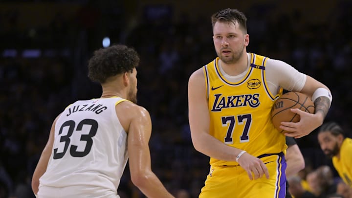 Feb 10, 2025; Los Angeles, California, USA; Los Angeles Lakers guard Luka Doncic (77) is defended by Utah Jazz guard Johnny Juzang (33) in the first half at Crypto.com Arena. Mandatory Credit: Jayne Kamin-Oncea-Imagn Images
