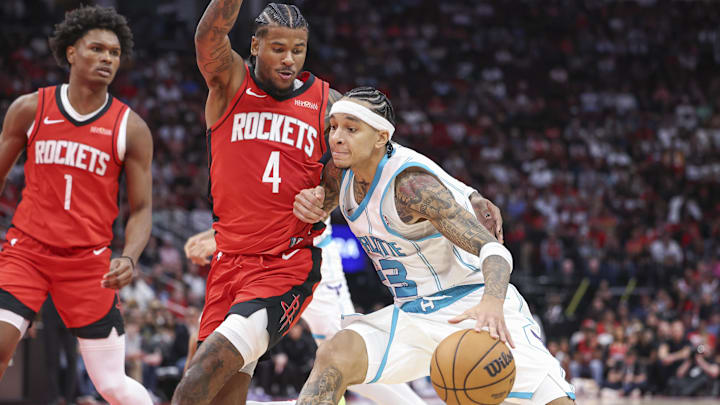 Oct 23, 2024; Houston, Texas, USA; Charlotte Hornets guard Tre Mann (23) drives with the ball as Houston Rockets guard Jalen Green (4) defends during the fourth quarter at Toyota Center. Mandatory Credit: Troy Taormina-Imagn Images