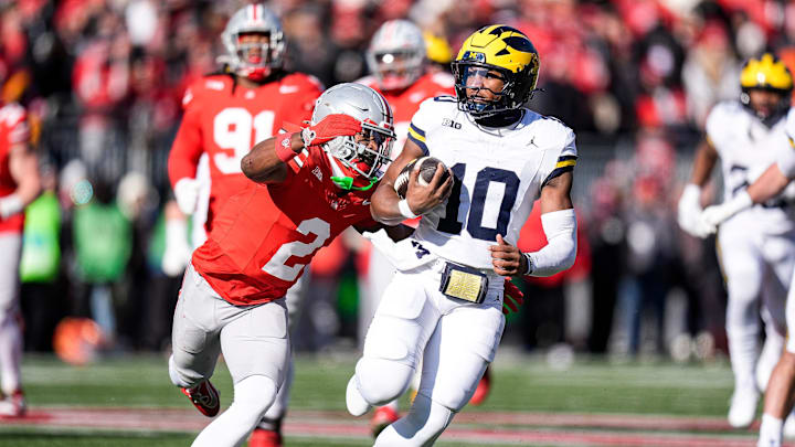 Michigan quarterback Alex Orji (10) runs against Ohio State safety Caleb Downs (2) during the first half at Ohio Stadium in Columbus, Ohio on Saturday, Nov. 30, 2024.