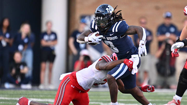 Sep 14, 2024; Logan, Utah, USA;  Utah State Aggies running back Rahsul Faison (3) is brought down by Utah Utes linebacker Levani Damuni (3) after a short gain in the second half at Merlin Olsen Field at Maverik Stadium. Mandatory Credit: Jamie Sabau-Imagn Images